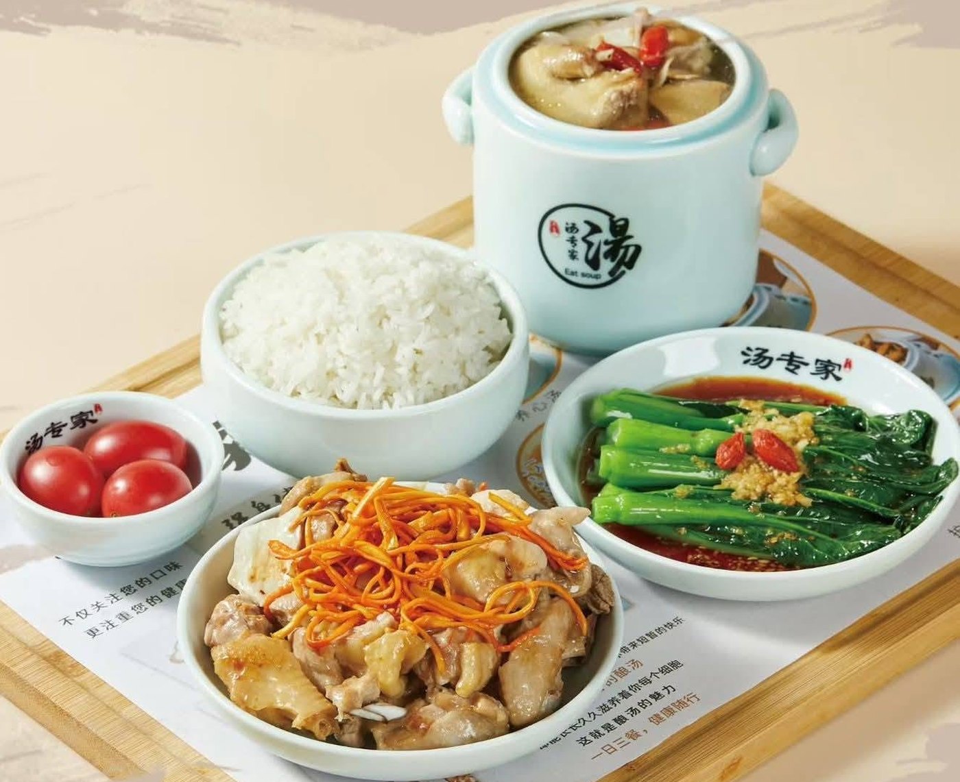 A HANQING set meal: herbal soup in a lidded pot, rice, chicken with cordyceps flowers, and greens on a bamboo tray